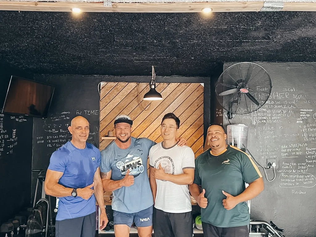 Four people giving a thumbs-up in the XO Fit gym